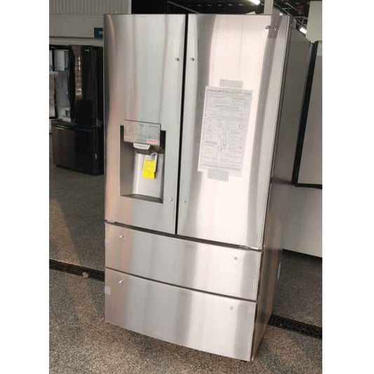 A stainless steel French door refrigerator with a bottom freezer drawer, a water and ice dispenser on the left door, and a paper instruction sheet taped to the right door, photographed in a showroom.